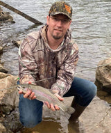Pond Pro Guide, Tim Shannon, holding a trout in the Spring River in Arkansas.