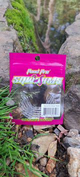 A package of Sqworms Silver Flake Reusable Soft Plastics placed on a rock with water and moss in the background.