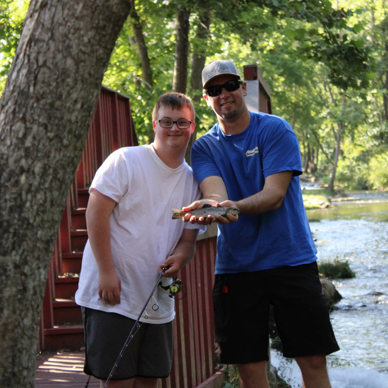 A young boy fishing at Dry Run Creek in Arkansas with Pond Pro Tim Shannon.