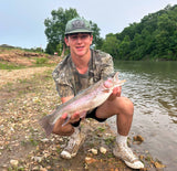 A young boy holding a large trout that he caught while wade fishing the Spring River in Arkansas.