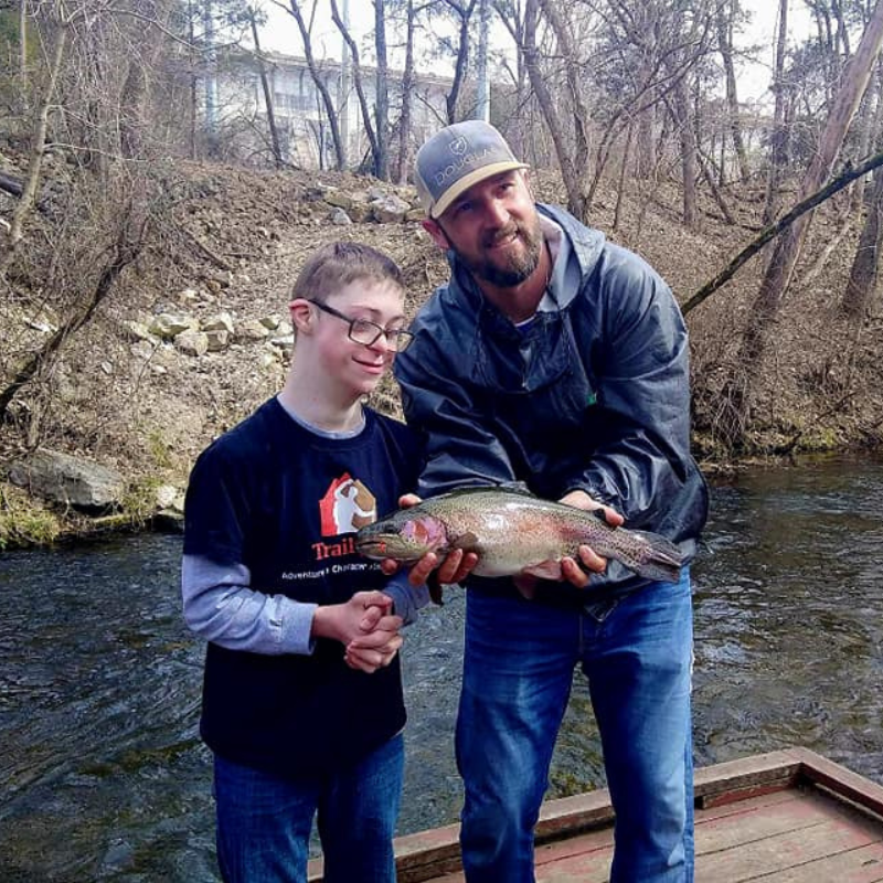 A young boy fishing with Pond Pro Guide Tim Shannon at Dry Run Creek in Arkansas.