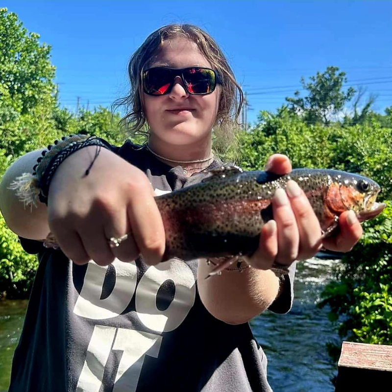 A young girl displaying the trout she caught while fishing with Pond Pro Guide Tim Shannon at Dry Run Creek.