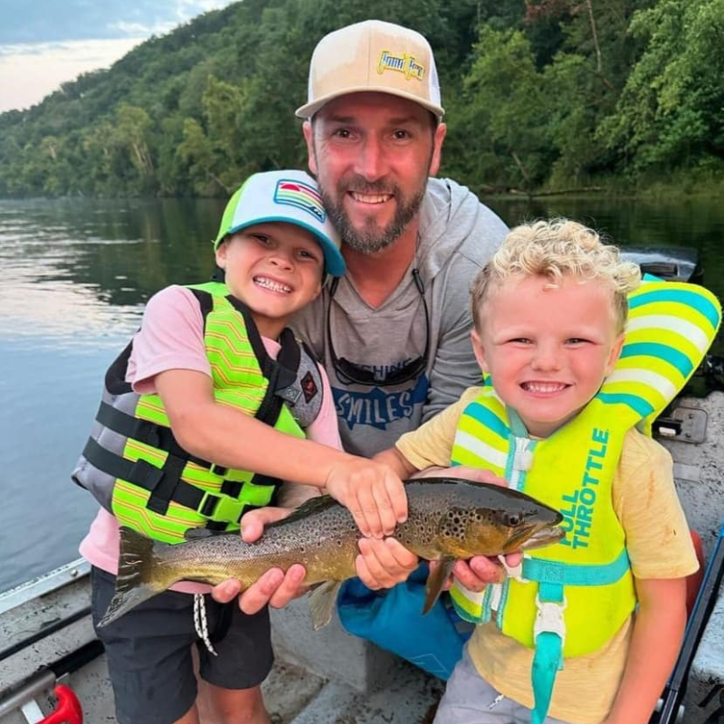 Pond Pro Tim Shannon fishing with two boys on a guide trip. They are holding a trout they caught.