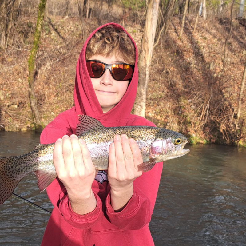 Young boy holding a trout while fishing with Pond Pro Guide Tim Shannon at Dry Run Creek.