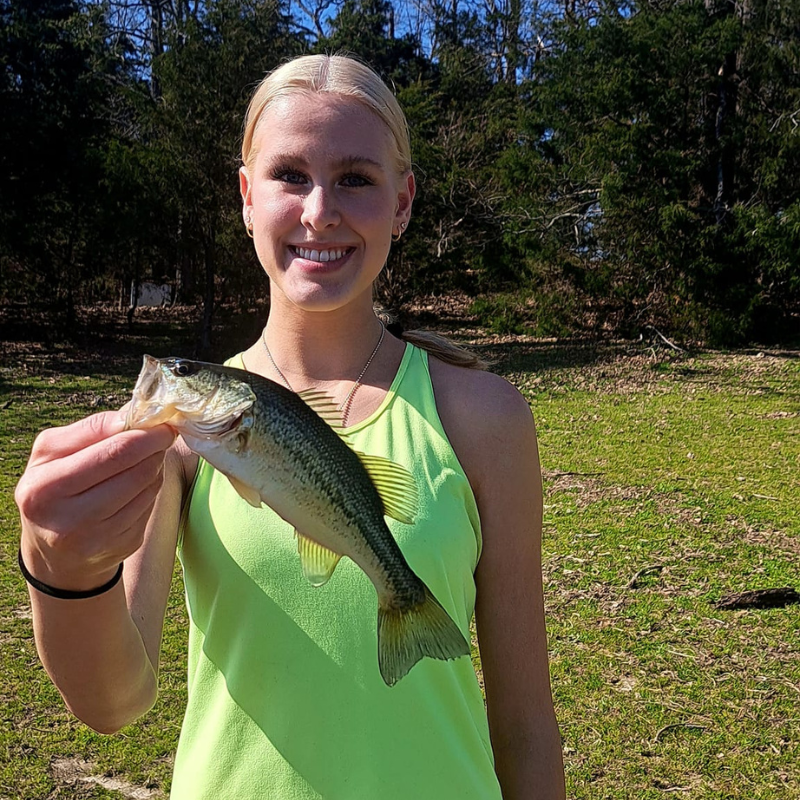 Young girl holding a fish caught while fishing with Pond Pro Tim Shannon