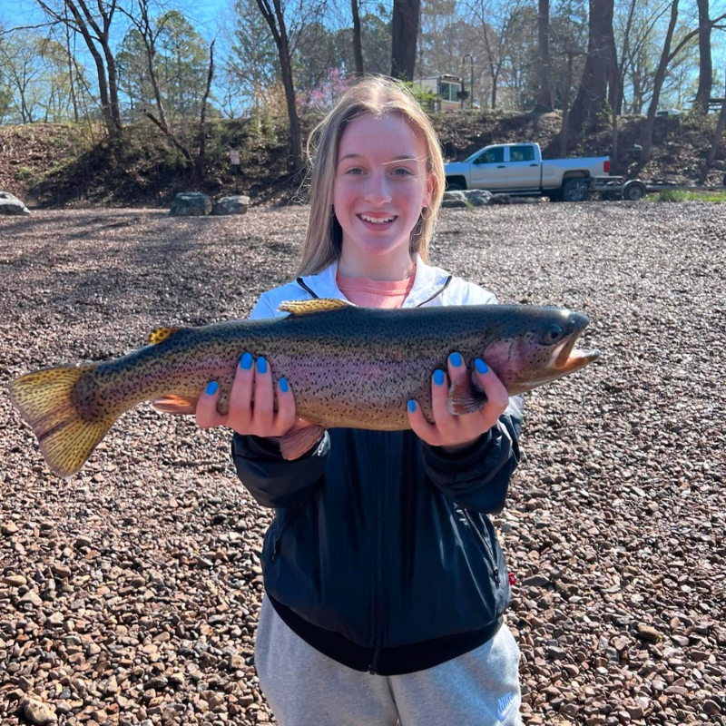 Young girl holding large fish while fishing with Pond Pro Tim Shannon.