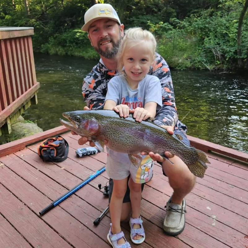 Young with Pond Pro Tim Shannon, holding a trout they caught at Dry Run Creek in Arkansas.