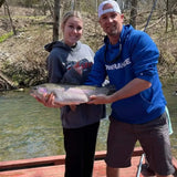 Older girl who caught a massive trout at Dry Run Creek in Arkansas, standing next to Pond Pro Guide, Tim Shannon.