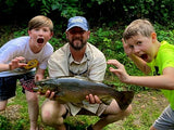 Two kids fishing with Pond Pro, Tim Shannon, at Dry Run Creek, holding a large trout.