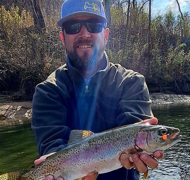 Pond Pro Guide Tim Shannon holding trout caught with orange scorn