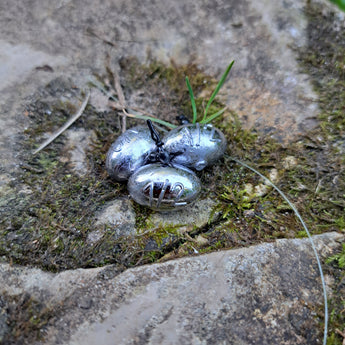 Three Pond Pro Up-Shot weights on a stone with moss.