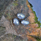 Three 1/2 oz Pond Pro Up-Shot weights on a rock near water.