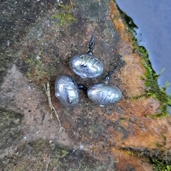 Three 1/2 oz Pond Pro Up-Shot weights on a rock near water.