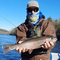 Pond Pro Guide, Tim Shannon, holding a large fish while on a boat in the White River in Arkansas.  In the winter, wearing a heavy coat.