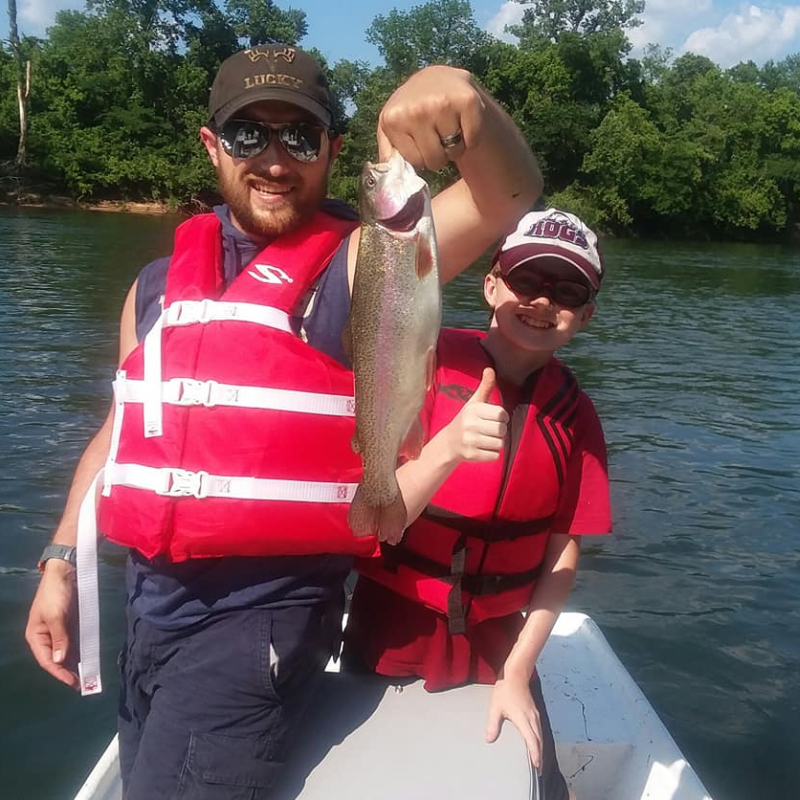 Father and son fishing with Pond Pro Tim Shannon, holding a fish.