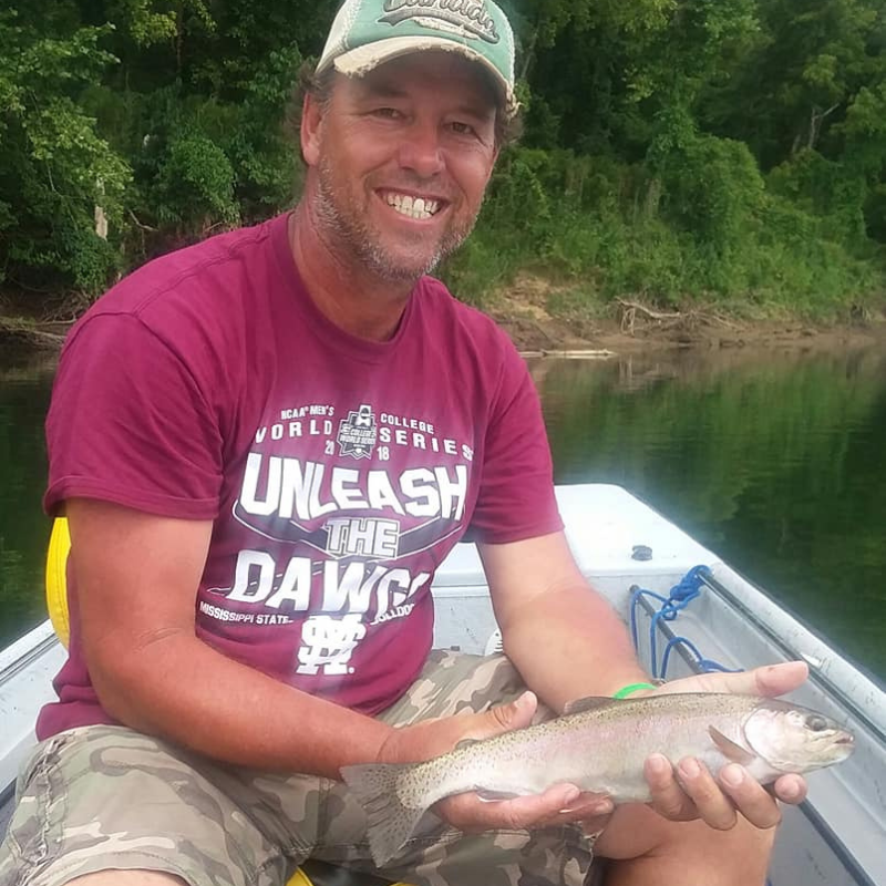 Man in boat holding a fish while fishing with Pond Pro Tim Shannon