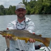 Pond Pro Guide, Tim Shannon, holding a large trout on the White River in Arkansas.