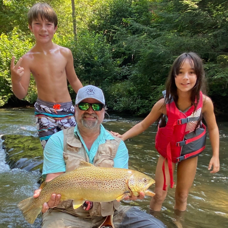 Pond Pro Guide Michael Willett with kids at the river holding a large fish.