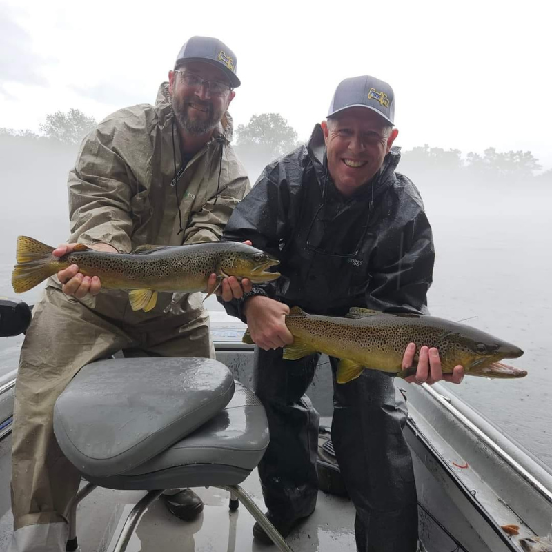 Pond Pro Guide Tim Shannon and uncle both holding fish while fishing in the fog on a boat.